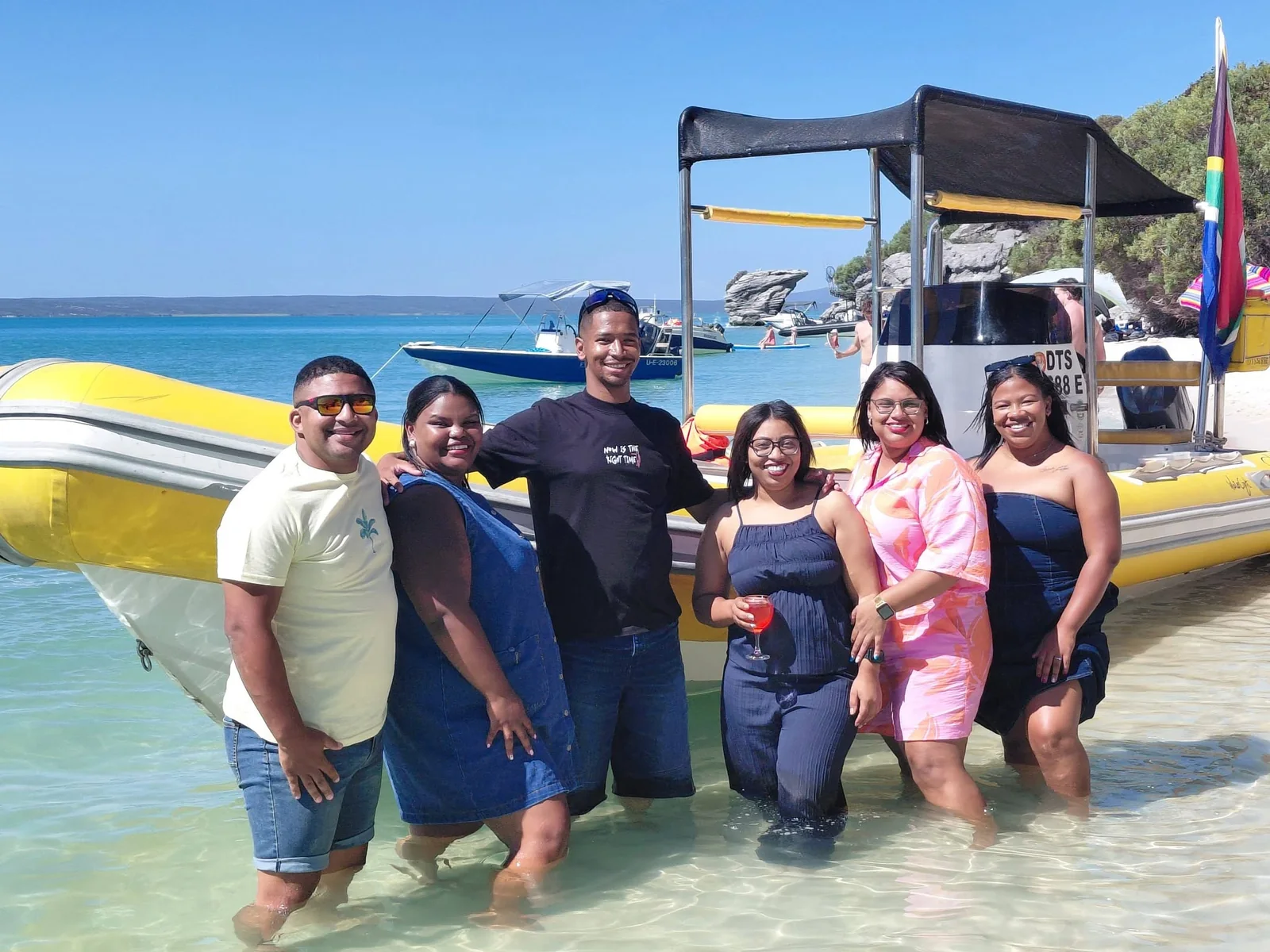 Aqua Vibes guests standing beside the yellow boat on Langebaan Lagoon